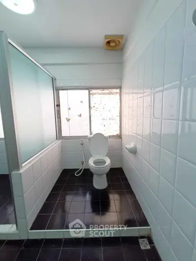 Spacious bathroom with modern fixtures and frosted glass partition