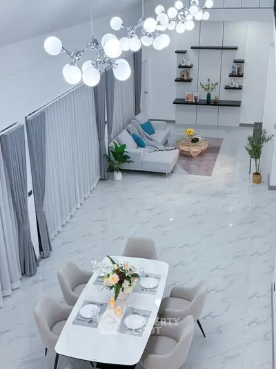 Luxurious open-plan living and dining area with modern decor and elegant lighting.