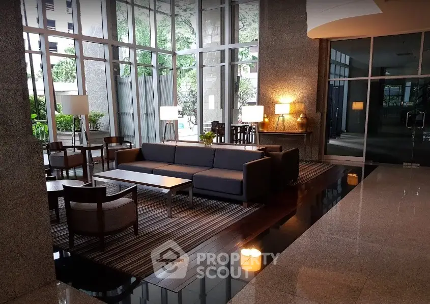 Luxurious modern lobby with elegant seating and floor-to-ceiling windows in a high-end building.