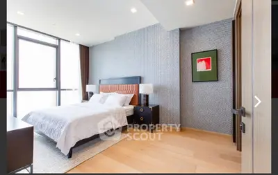 Modern bedroom with stylish decor and large window offering natural light