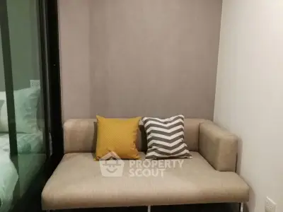 Cozy small living room with modern beige sofa and colorful cushions