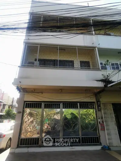 Spacious multi-story building with secure gated entrance in urban setting, ideal for commercial or residential use.