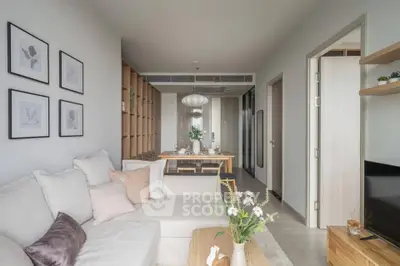 Modern living room with cozy sofa and elegant dining area in open layout apartment.