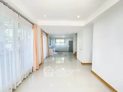 Spacious and bright living room with large windows and glossy floors