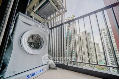 Modern balcony with washing machine and city skyline view in high-rise apartment.
