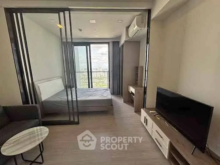 Modern studio apartment with glass partition, cozy living area, and scenic city view.