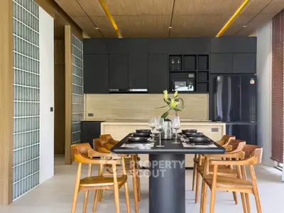 Modern kitchen with sleek black cabinets and elegant dining area featuring wooden chairs and table.