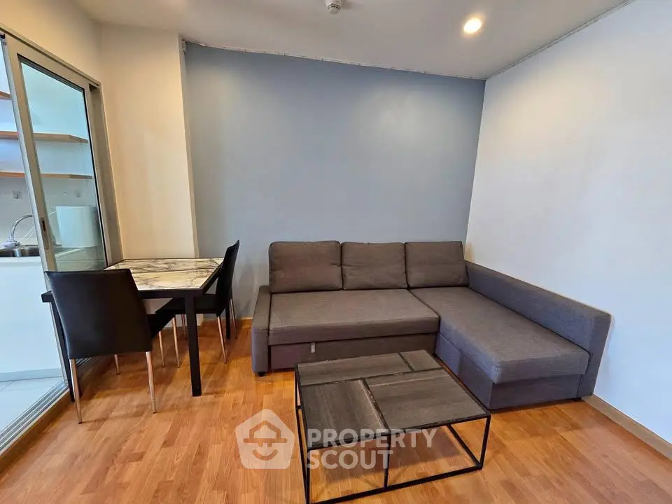 Modern living room with sleek gray sofa and stylish dining area, perfect for urban living.