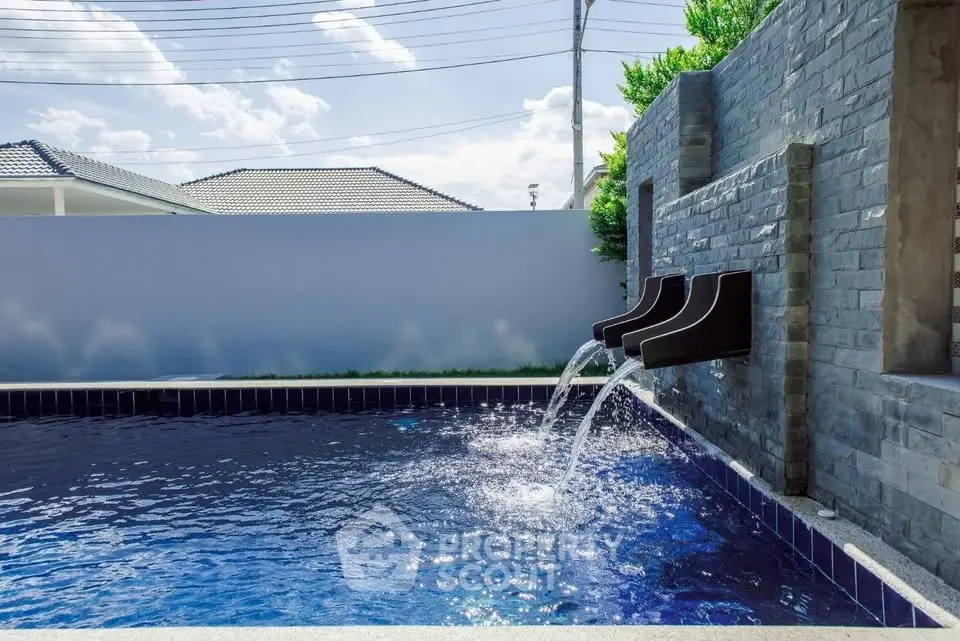 Luxurious private pool with modern water features and serene surroundings.