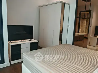 Modern bedroom with sleek furniture and large wardrobe in a stylish apartment.