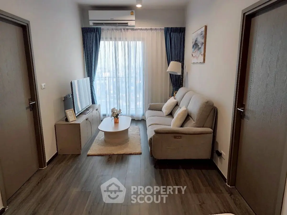 Modern living room with cozy sofa, stylish decor, and large window with city view.