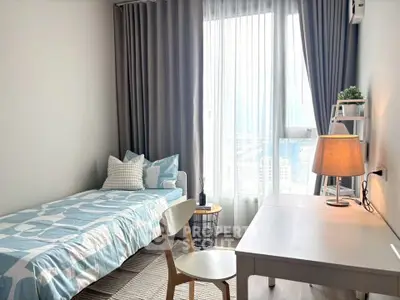 Cozy bedroom with single bed, desk, and city view through large window.