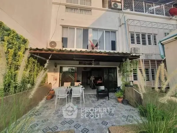 Charming townhouse with spacious patio and lush greenery, perfect for outdoor relaxation and entertaining.