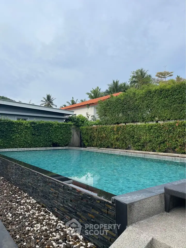 Luxurious private pool with lush greenery and modern design, perfect for relaxation and entertainment.