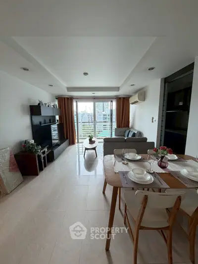 Spacious living room with dining area and city view balcony in modern apartment.