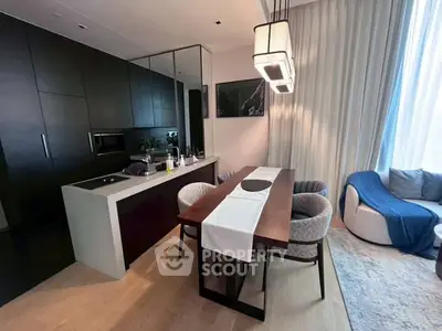 Modern open-plan kitchen and dining area with sleek design and cozy seating.