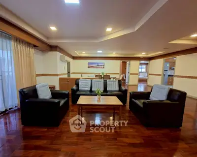 Spacious living room with elegant wooden flooring and modern furniture in a luxurious apartment.