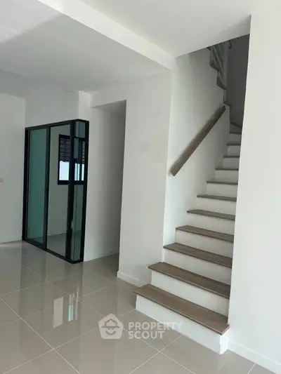 Modern interior with sleek staircase and glossy tiled flooring