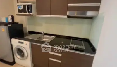 Modern kitchen with sleek cabinets, washing machine, and built-in appliances for efficient living.