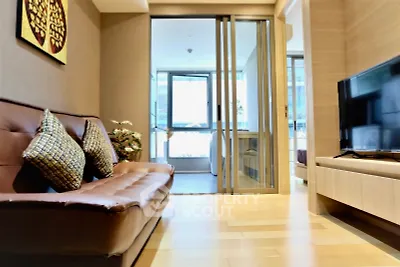 Modern living room with sleek design and sliding glass doors leading to a bright balcony.