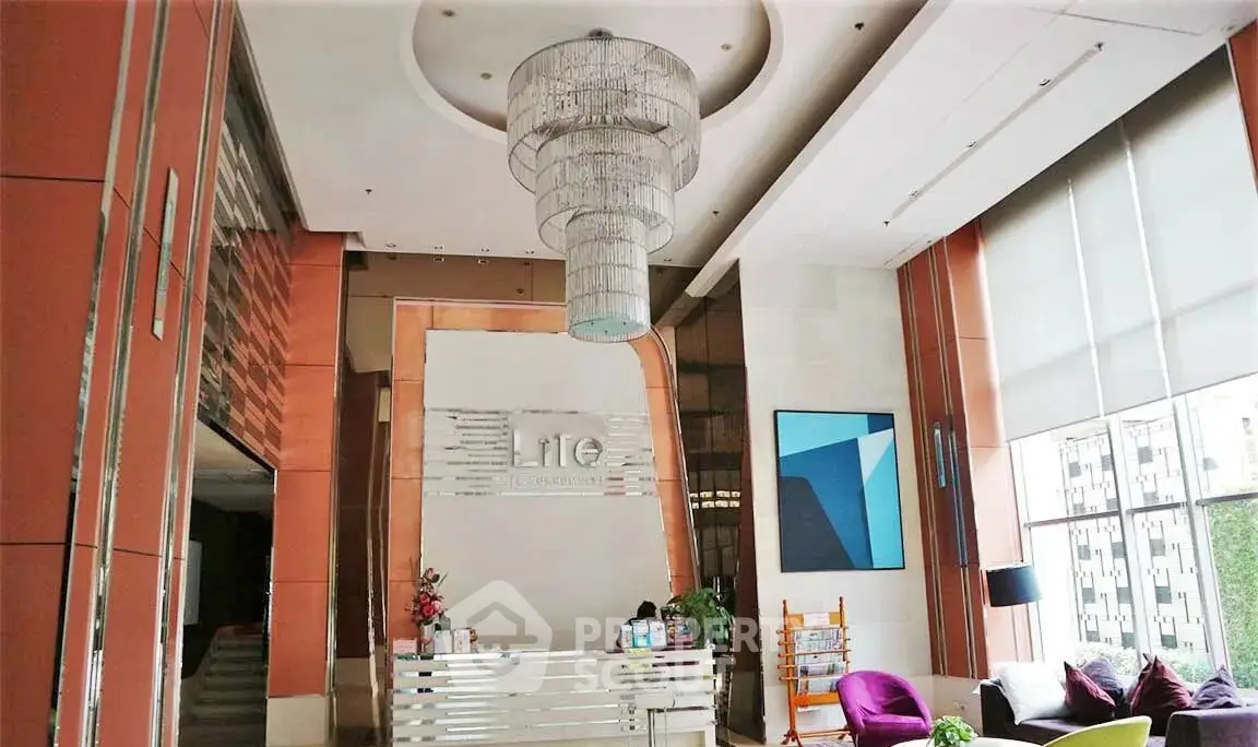 Luxurious building lobby with modern chandelier and stylish seating area