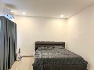 Cozy bedroom with modern gray bedding and air conditioning, perfect for restful nights.