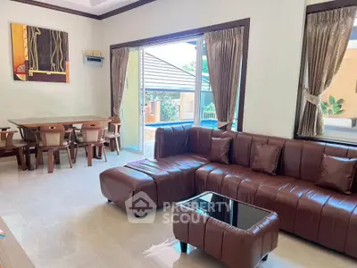 Spacious living room with modern brown leather sofa and pool view, perfect for relaxation and entertaining.