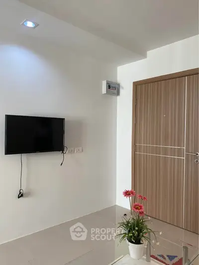 Modern living room with wall-mounted TV and stylish wooden door