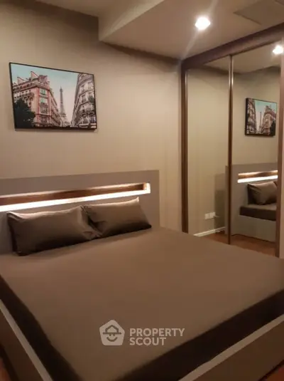 Modern bedroom with mirrored closet and stylish decor in a cozy apartment.