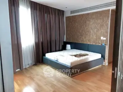 Spacious bedroom with modern design and large window for natural light.
