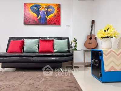 Stylish living room with modern decor, vibrant artwork, and cozy seating area.