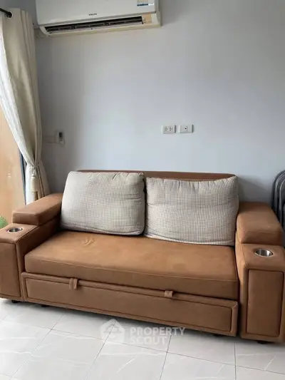 Cozy living room with stylish brown sofa and modern air conditioning unit.
