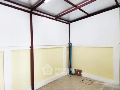 Spacious storage room with tiled floor and high ceiling, ideal for versatile use.