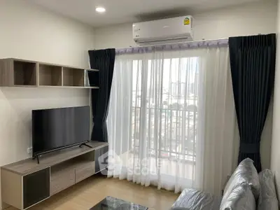 Modern living room with large TV and balcony view