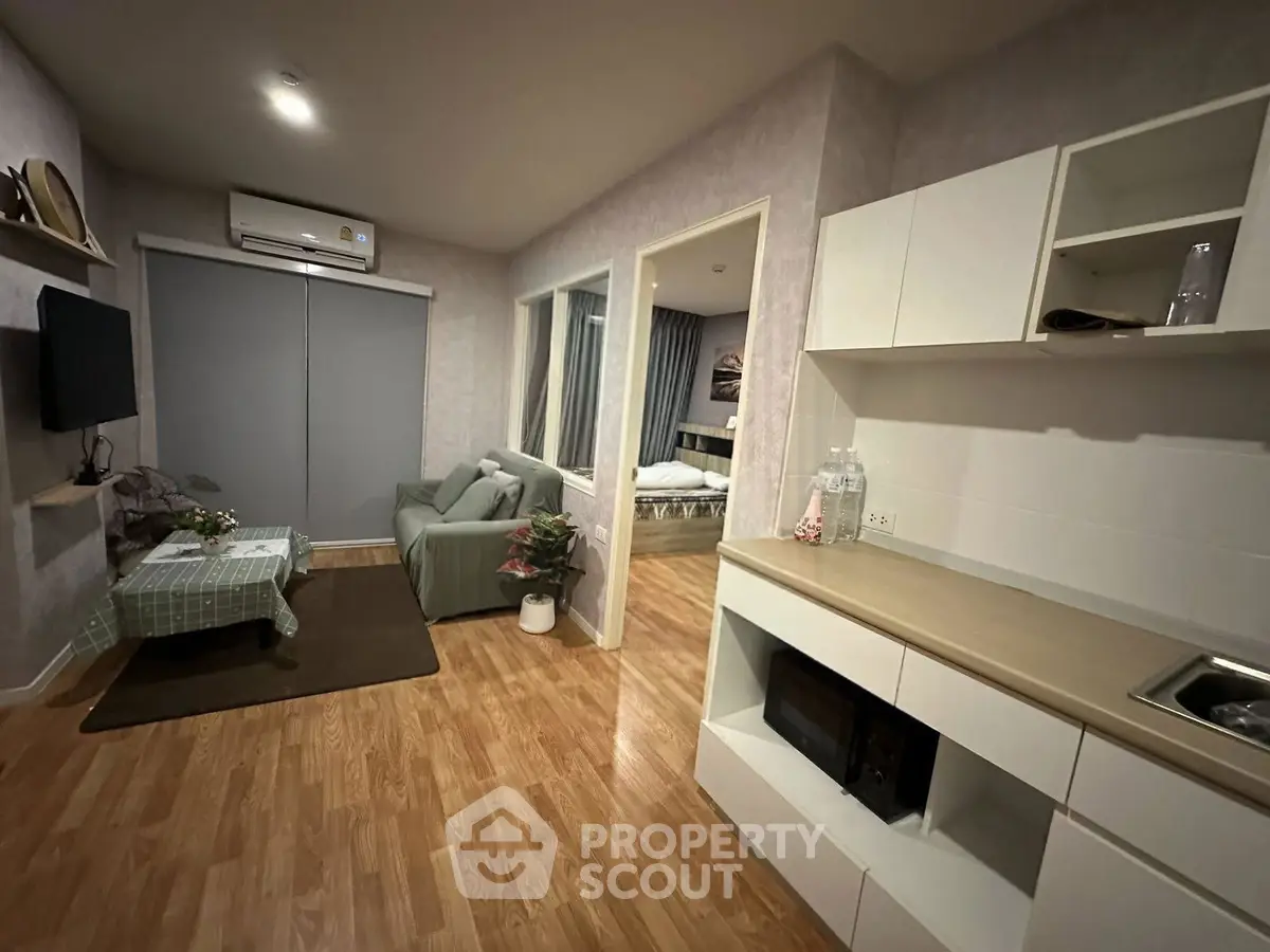 Modern open-plan living room with cozy seating and stylish kitchen area, perfect for urban living.