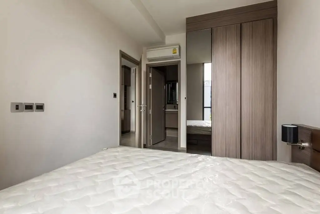 Modern bedroom with sleek wardrobe and comfortable mattress in a stylish apartment.