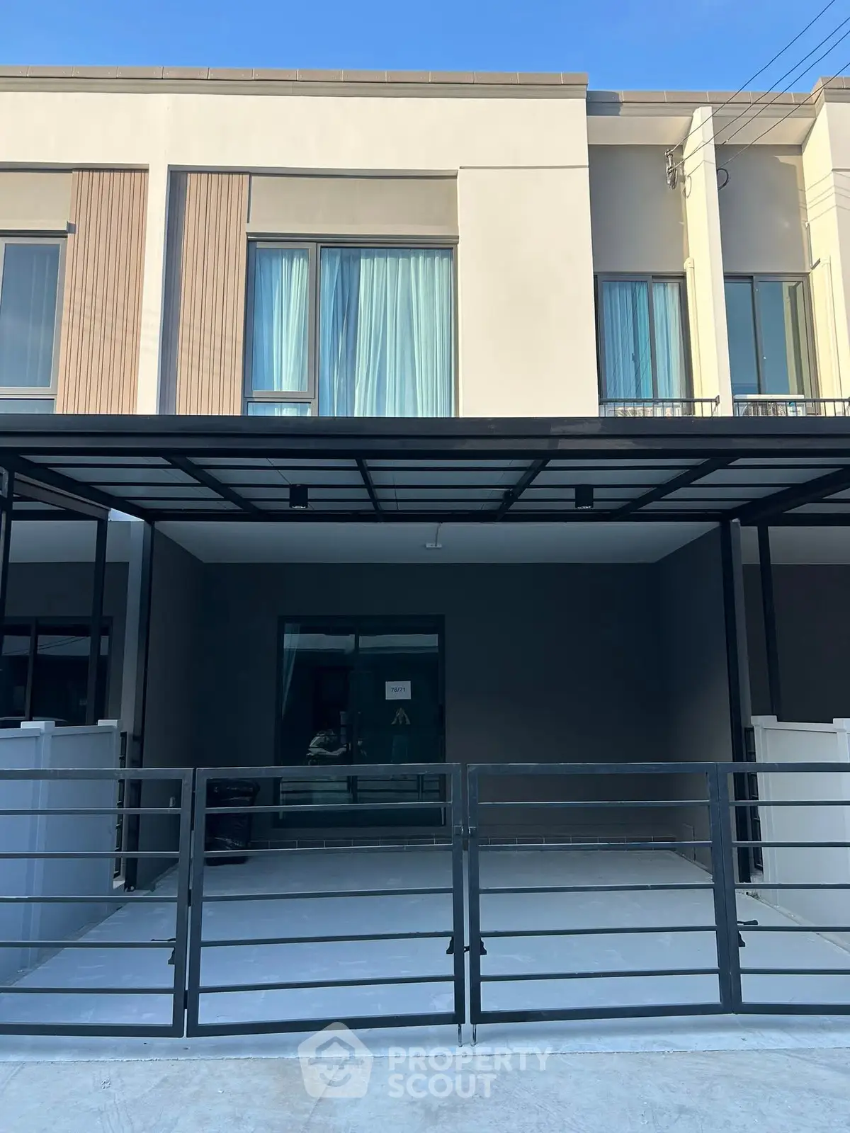 Modern townhouse exterior with sleek design and spacious driveway.