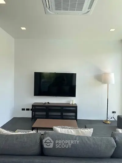 Modern living room with sleek TV setup and stylish furniture, perfect for relaxation and entertainment.