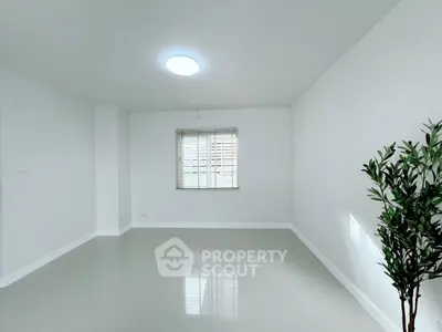 Spacious minimalist room with large window and glossy tiled floor, perfect for modern living.