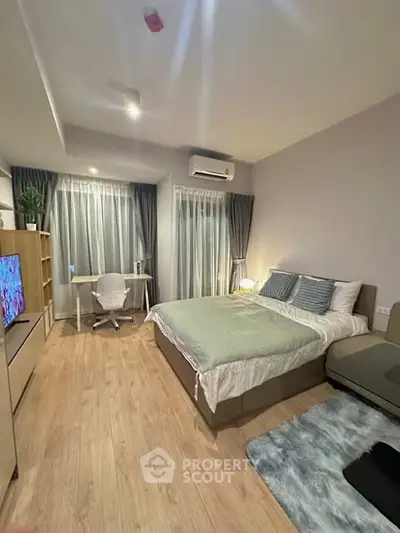 Modern bedroom with cozy decor, featuring a large bed, study desk, and stylish curtains.