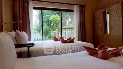 Cozy bedroom with twin beds and garden view, perfect for relaxation.