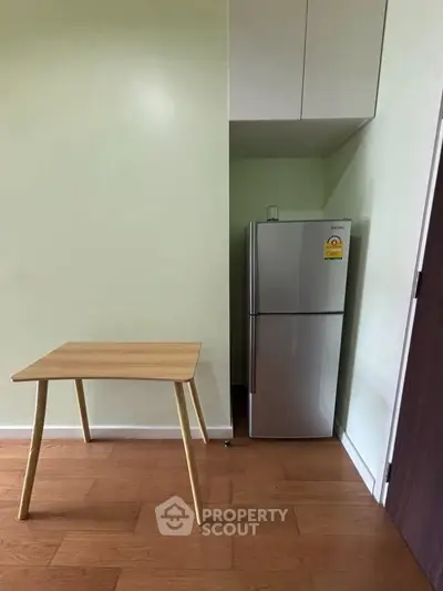 Compact kitchen corner with modern fridge and minimalist wooden table