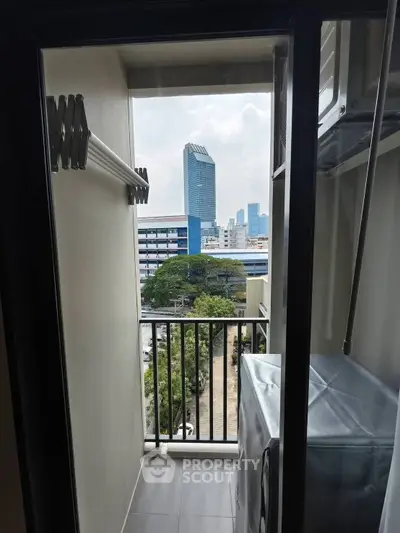 Compact balcony with city view and laundry area in modern apartment