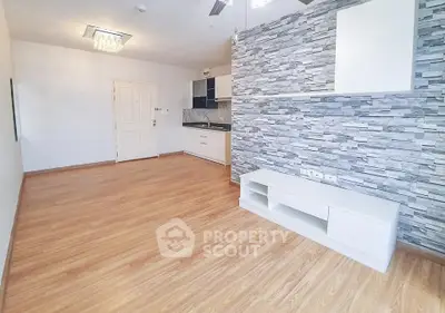 Modern living room with stylish stone accent wall and open kitchen layout