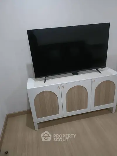 Modern living room with sleek TV stand and large flat-screen television.