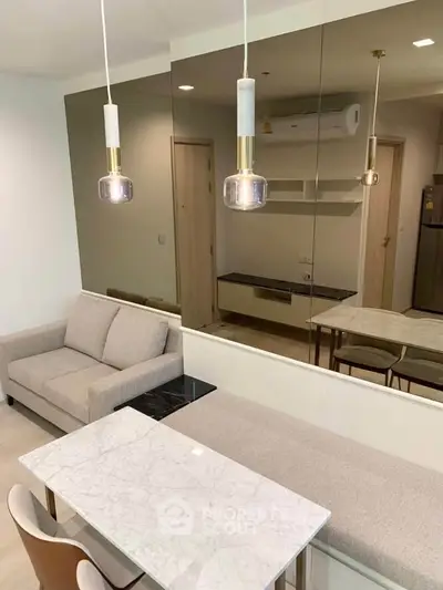 Modern living room with elegant marble dining table and cozy sofa, featuring stylish pendant lights and mirrored wall.