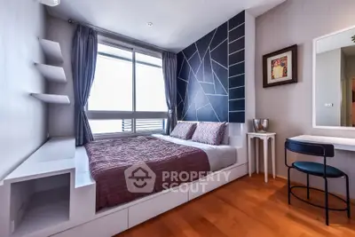 Modern bedroom with stylish decor and large window for natural light.