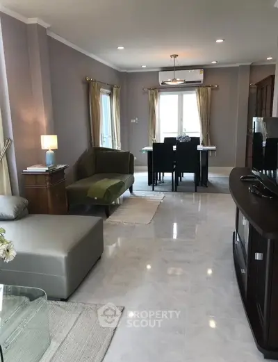 Spacious living room with modern decor and dining area, perfect for entertaining.