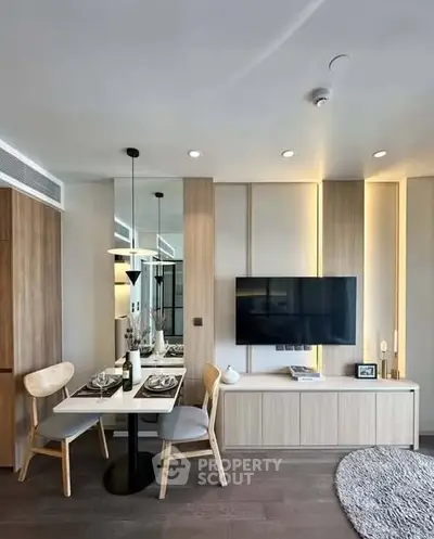 Modern living room with dining area, wall-mounted TV, and stylish decor