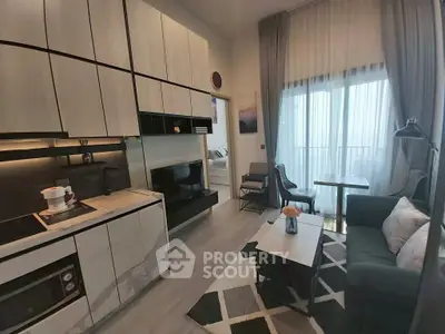 Modern open-plan living room with sleek kitchen and balcony access